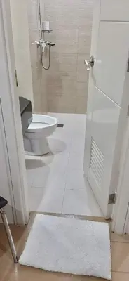 a bathroom with a toilet and a shower and a rug at ZG-150Newport in Manila