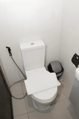 a bathroom with a white toilet and a black trash can at mySTAY Hotel BGC East in Manila
