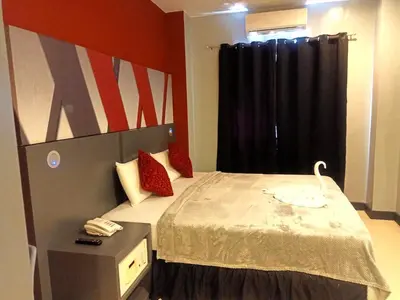 a bedroom with a bed with a swan on it at Wow Budget Hotel Cubao in Manila