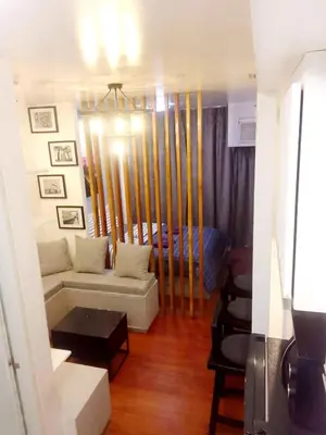 a living room with a couch and a bed at The Linear Makati Condo Stunning Hotel Type Interior in Manila