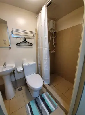 a bathroom with a white toilet and a sink at Lilian Stanford Suites 2 South Forbes Inchican Silang Cavite in Silang