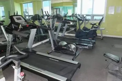 a gym with a bunch of treadms and machines at USA embassy front suite Pearl of the Orient in Manila