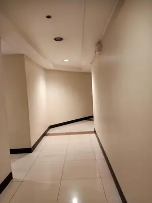 an empty room with white walls and a tile floor at Taj's Condotel in Manila