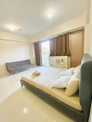 a bedroom with a large bed and a window at Hotel Type Condo Near NAIA Manila Airport in Manila