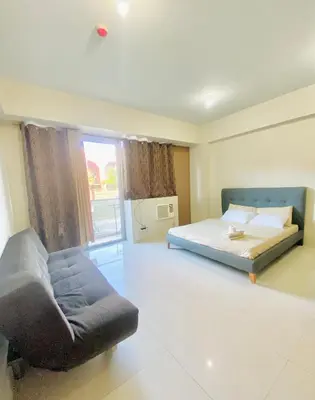 a bedroom with a bed and a couch and a window at Hotel Type Condo Near NAIA Manila Airport in Manila