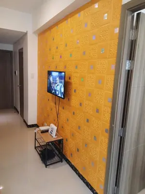 a room with a yellow wall with a tv on it at SMDC FAME Residences David 's place in Manila