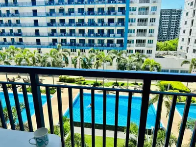 a balcony with a view of a pool and buildings at Sea Residences Tower F Angel 0975 - 811 - 9490 in Manila