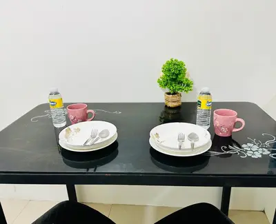 a black table with plates and forks and water at Sea Residences Tower F Angel 0975 - 811 - 9490 in Manila