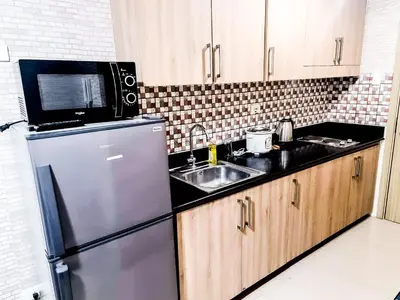 a kitchen with a stainless steel refrigerator and a sink at Sabina's one bedroom condo at Shore tower C in Manila