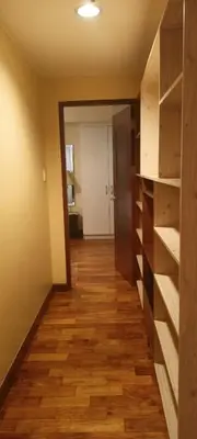 a hallway of a room with wooden floors and shelves at 18F staycation in Manila