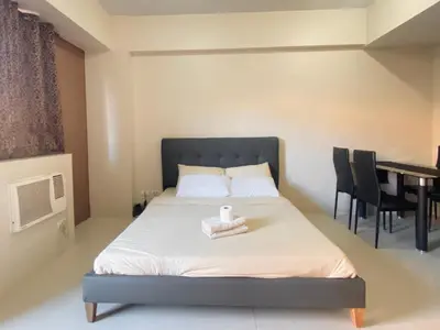 a bedroom with a bed with a table and chairs at Luxury Hotel Type Condo Near NAIA Manila Airport in Manila