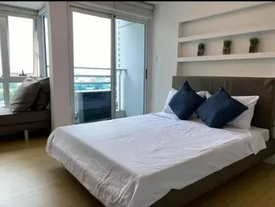 a bedroom with a large bed with blue pillows at A2J Luxury 1BR BGC Balcony Suite Near BurgosCircle in Manila