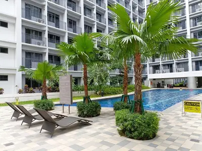 a hotel with palm trees and a swimming pool at Home away from Home in Manila