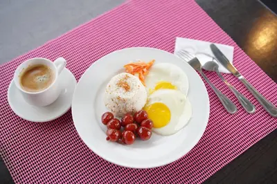 a plate of eggs and grapes and a cup of coffee at Arzo Hotel Premier in Manila