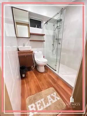 a bathroom with a shower and a toilet and a sink at Panoramic View of City 1BR Loft Unit FREE WIFI & NETFLIX at Fort Victoria BGC in Manila