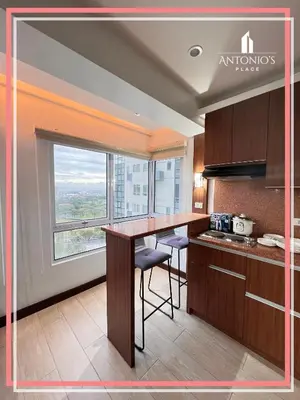a kitchen with a table and a large window at Panoramic View of City 1BR Loft Unit FREE WIFI & NETFLIX at Fort Victoria BGC in Manila