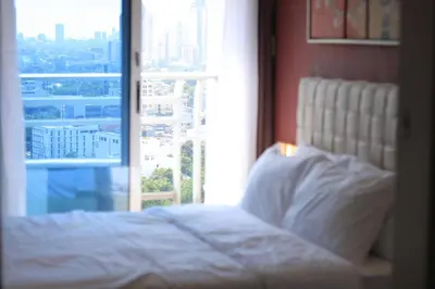 a bed in a room with a large window at A2J BGC Luxury 1BR Suite Near Burgos Circle & Mall in Manila