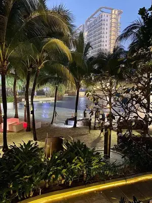 a view of a beach with palm trees and a building at Azure Urban Resort in Manila