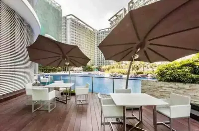 a patio with tables and chairs and umbrellas at S-A-F-E Haven Resort Staycation in Manila