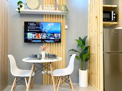 a table and chairs in a kitchen with a tv at Will’s Place @ Shore2 Residences Mall of Asia in Manila