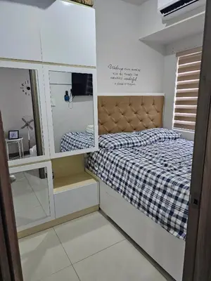 a small bedroom with a bed and a mirror at Mel and Rose Place in S Residences Tower 1 MOA in Manila