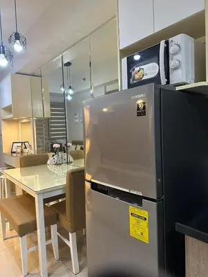 a kitchen with a stainless steel refrigerator and a table at Mel and Rose Place in S Residences Tower 1 MOA in Manila