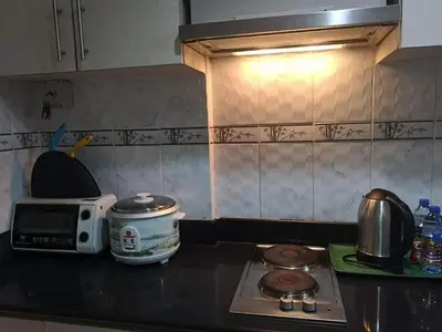 a kitchen counter with a stove and a microwave at Sea Residences Prestige in Manila