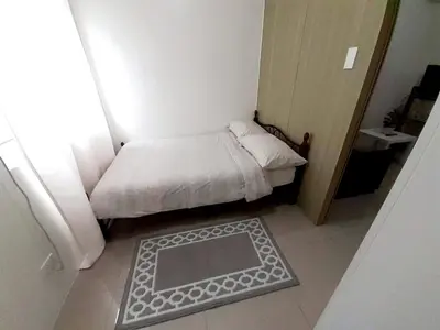 a small bedroom with a small bed and a window at Shore 1 Residences,MOA Complex - One Bedroom Apartment in Manila