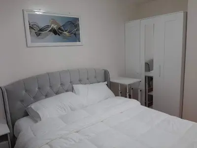 a bedroom with a white bed and a picture on the wall at Lovely 2 BR Condo with FREE Secured Parking in Manila