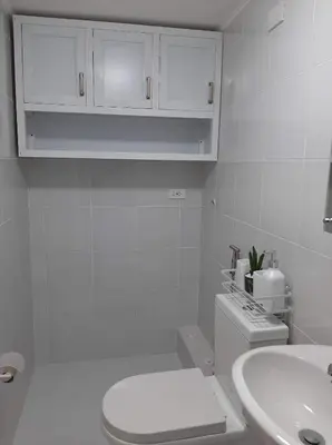 a white bathroom with a toilet and a sink at Lovely 2 BR Condo with FREE Secured Parking in Manila