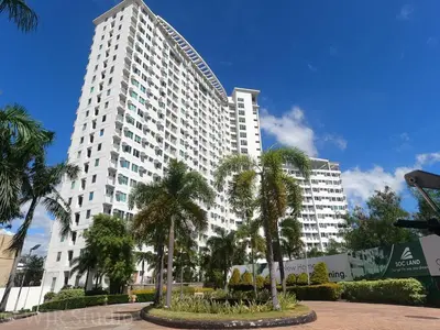 a large white building with palm trees in front of it at Choco Condotel- Anuva Prime 2 Cozy & Stylish Place in the Metro in Manila