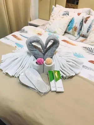 a bed with two swan towels and a laptop on it at Luxurious Condotel at the heart of Makati in Manila