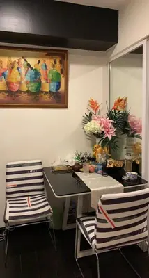 a room with two chairs and a table with flowers at Azure Urban Resort in Manila