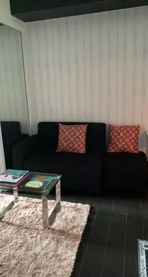 a living room with a black couch and a table at Azure Urban Resort in Manila