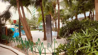 a park with palm trees and plants and a sign at Azure Urban Resort in Manila
