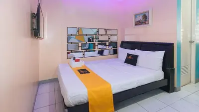 a bedroom with a bed with a yellow blanket on it at 4720 Silverio Suites Paranaque City in Manila