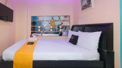 a bedroom with a large bed with white sheets at 4720 Silverio Suites Paranaque City in Manila