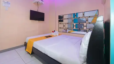 a room with two beds and a tv on the wall at 4720 Silverio Suites Paranaque City in Manila