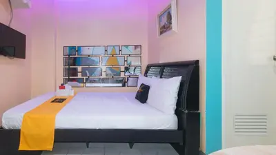 a bedroom with a large bed with a yellow blanket at 4720 Silverio Suites Paranaque City in Manila