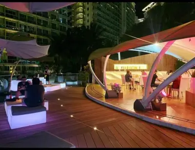a group of people sitting on a deck at night at S-a-f-e Haven Resort Staycation in Manila