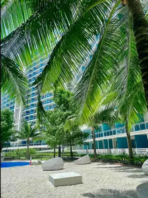 a building with palm trees in front of a beach at S-a-f-e Haven Resort Staycation in Manila