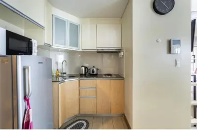 a kitchen with a refrigerator and a clock on the wall at Studio at Newport World Airport Area Prime Location in Manila