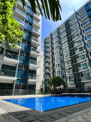 a swimming pool in front of two tall buildings at Studio at Newport World Airport Area Prime Location in Manila