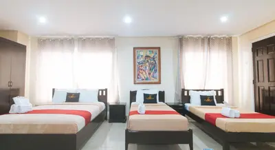 two beds in a room with windows and curtains at 153 Silverio Suites Paranaque City in Manila