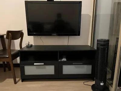 a black entertainment center with a flat screen tv on top at Ramiro Haven Staycation in Manila