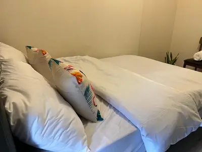 a white bed with two pillows on it at Ramiro Haven Staycation in Manila