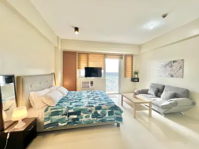 a bedroom with a bed and a couch in it at Luxury Condotel Across NAIA Manila Airport in Manila