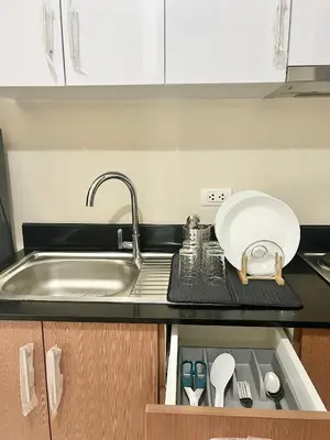 a kitchen counter with a sink and a plate and utensils at Luxury Condotel Across NAIA Manila Airport in Manila