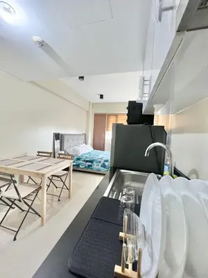 a kitchen with a sink and a table and a couch at Luxury Condotel Across NAIA Manila Airport in Manila
