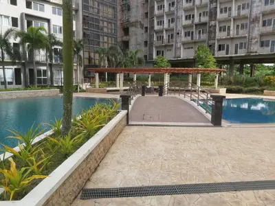 a walkway next to a pool in a building at Affordable Tagaytay Monteluce 1BR with Pool G10 in Lalaan Primero